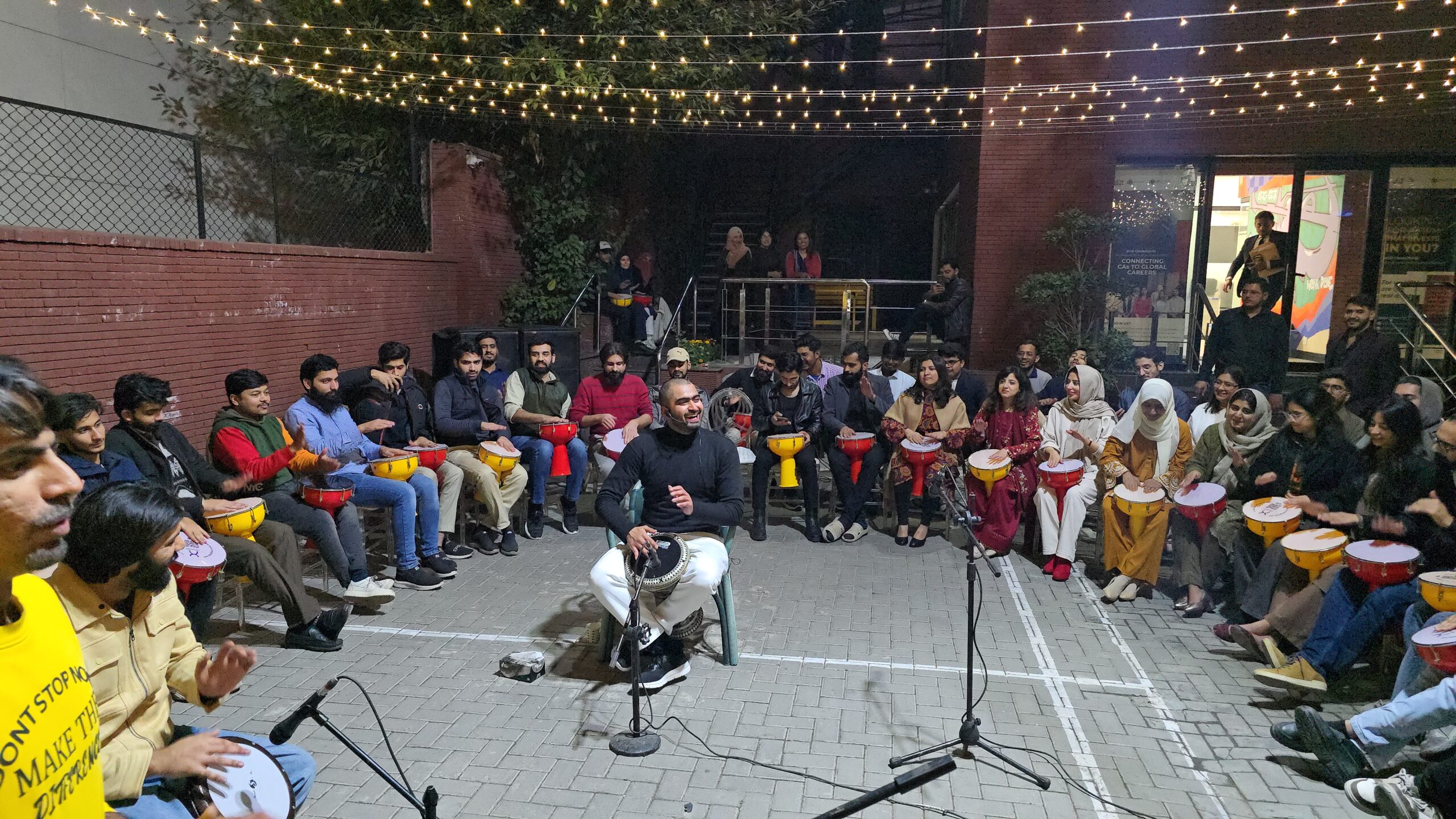 Drum circle at QuickOffice, 304 Upper Mall, with professionals playing drums together in a lively team-building event.
